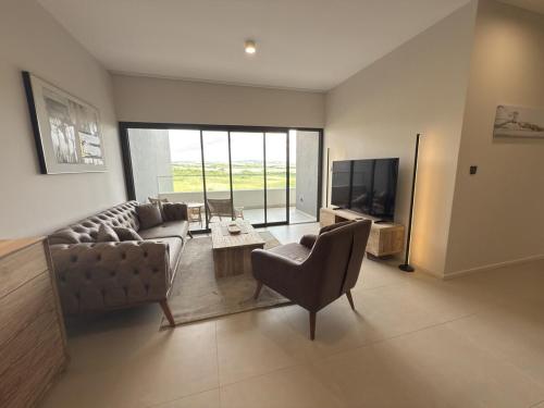 a living room with a couch and chairs and a television at Sky Sensation Two Rooms Apartment in Moka