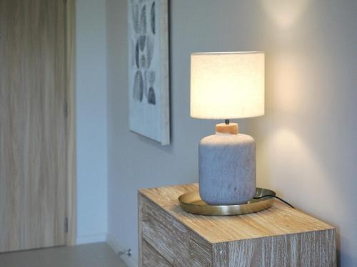 a lamp sitting on top of a wooden table at Sky Sensation Two Rooms Apartment in Moka