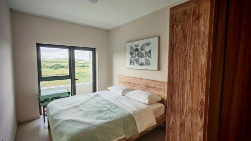 a bedroom with a large bed and a window at Sky Sensation Two Rooms Apartment in Moka