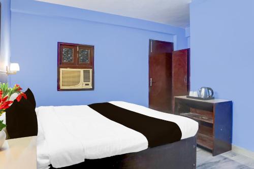 a bedroom with a bed with a blue wall at Hotel O Green Park Residency 2 in New Delhi