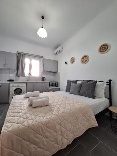a large bed in a room with a kitchen at Aegean Traditional Suite Ιn Glinado in Glinado Naxos