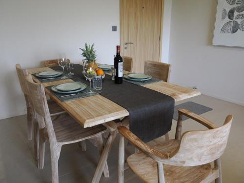 a dining room table with a bottle of wine on it at Sky Sensation Two Rooms Apartment in Moka