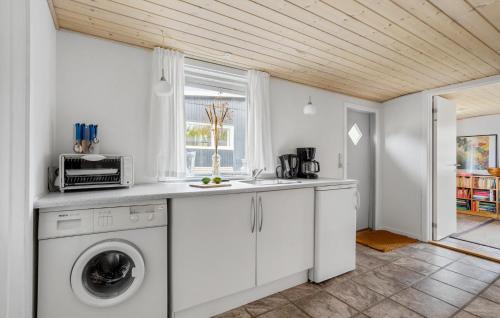 a kitchen with a washing machine and a sink at Lærkereden in Allinge