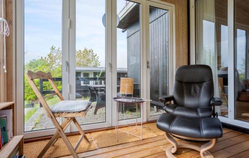 a black leather chair sitting in front of a window at Lærkereden in Allinge