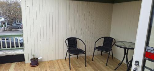 two chairs and a table on a porch at Storgata 78, Leknes sentrum in Leknes