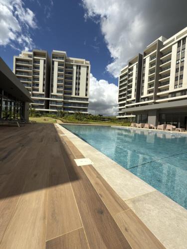 a swimming pool in front of two tall buildings at Sky Sensation Two Rooms Apartment in Moka