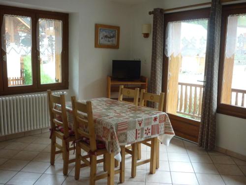 une salle à manger avec une table, des chaises et des fenêtres dans l'établissement Appartement 2 pièces 4 personnes 3* exposé Sud-Est au centre de Valloire, proche des remontées mécaniques - FR-1-263-83, à Valloire