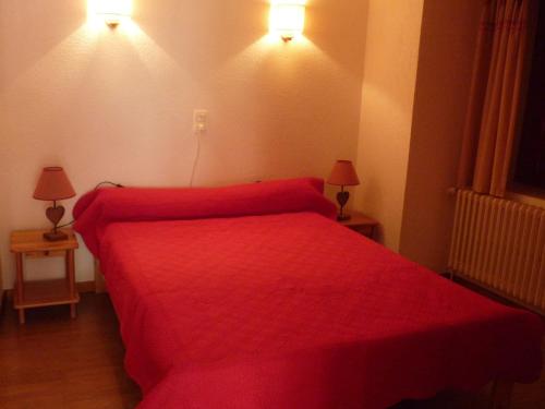 - un lit rouge dans une chambre avec deux lampes dans l'établissement Appartement 2 pièces 4 personnes 3* exposé Sud-Est au centre de Valloire, proche des remontées mécaniques - FR-1-263-83, à Valloire