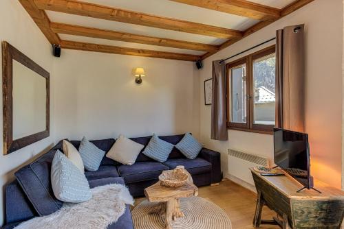 un salon avec un canapé bleu et une télévision dans l'établissement APARTMENT CHAMOUNY - Alpes Travel - Chamonix - Sleeps 8, à Chamonix-Mont-Blanc