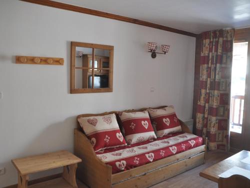 - un salon avec un canapé et des oreillers rouges dans l'établissement Appartement cosy 4 pers. avec balcon et WiFi - FR-1-263-392, à Valloire