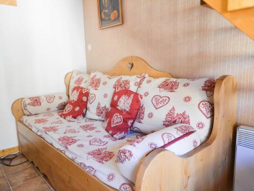 - un canapé avec des oreillers rouges et blancs dans l'établissement Charmant 2P cabine + mezzanine, 6 pers, exposé Ouest à Valloire, près du centre et des commodités - FR-1-263-185, à Valloire