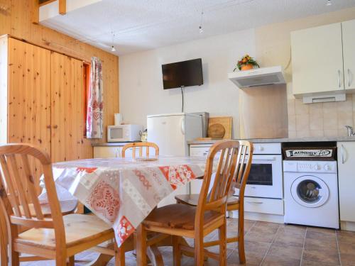 une cuisine avec une table avec des chaises et un micro-ondes dans l'établissement Charmant 2P cabine + mezzanine, 6 pers, exposé Ouest à Valloire, près du centre et des commodités - FR-1-263-185, à Valloire