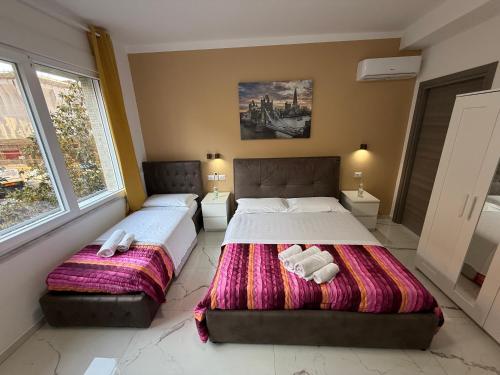 a bedroom with two beds and two windows at Desire guest House in Pisa