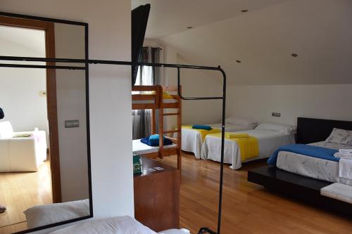 a room with two bunk beds and a mirror at A de Bego in Mougás