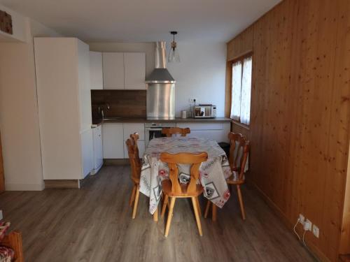 une cuisine et une salle à manger avec une table et des chaises dans l'établissement Appartement familial 3 pièces pour 8 personnes, terrasse et parking, centre de Valloire - FR-1-263-455, à Valloire