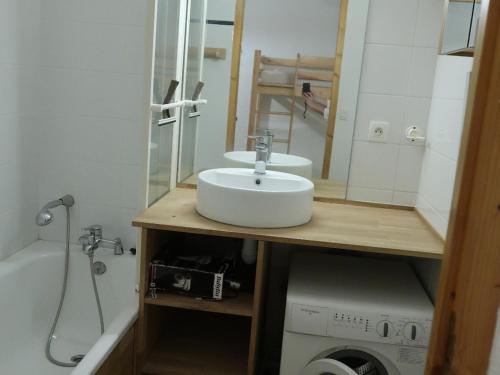une salle de bain avec un lavabo et une machine à laver dans l'établissement Appartement familial 3 pièces pour 8 personnes, terrasse et parking, centre de Valloire - FR-1-263-455, à Valloire