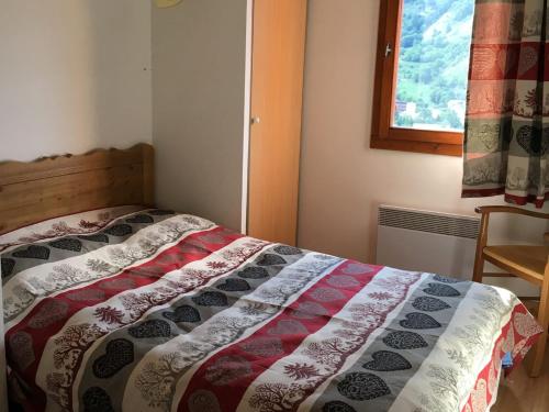 une chambre avec un lit avec une couette dessus dans l'établissement Charmant 2 Pièces 4 Pers Exposé Sud avec Balcon et Parking Privé à Valloire - FR-1-263-454, à Valloire