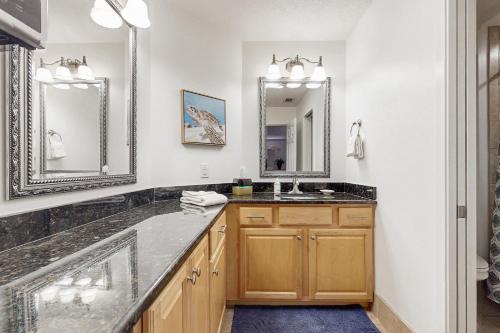 a bathroom with a sink and two mirrors at Ameila Island Plantation condo with beach access, private patio and pool. in Fernandina Beach