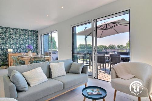 un salon avec un canapé et une terrasse dans l'établissement La cabane de saint sypher, à Le Pener