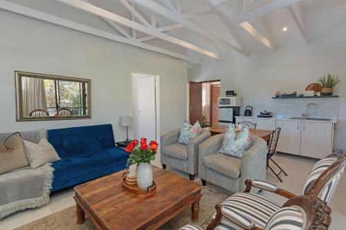a living room with a blue couch and chairs at Cape Goodness in Bellville
