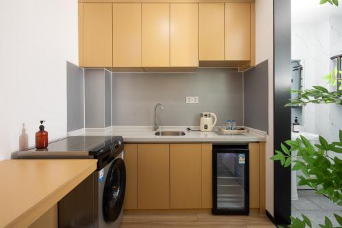 a kitchen with wooden cabinets and a washer and dryer at Amanda Hotel堆谷里酒店 in Phnom Penh