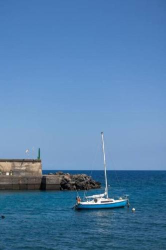a sail boat in the water near a pier at Charming place near the beach Casa Checha in Candelaria