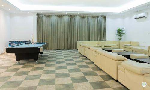 a large room with a pool table and couches at Greenland Farm in Dubai