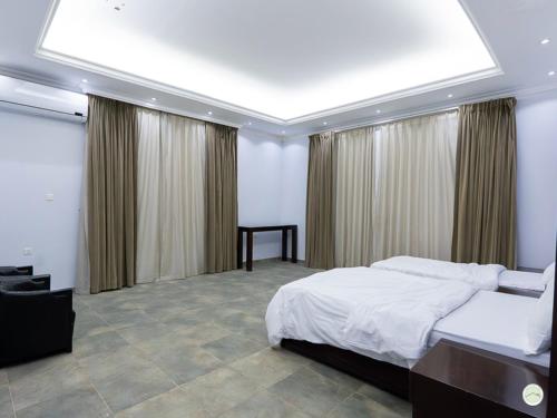 a bedroom with a large bed and a large window at Greenland Farm in Dubai