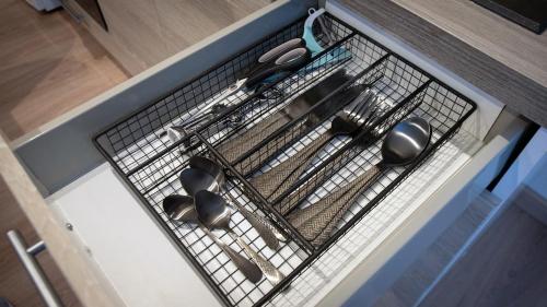 a wire rack with utensils on a kitchen counter at Au cœur des vignes Proche Disneyland in Crézancy