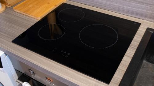 a stove top oven with three dials on a counter at Au cœur des vignes Proche Disneyland in Crézancy