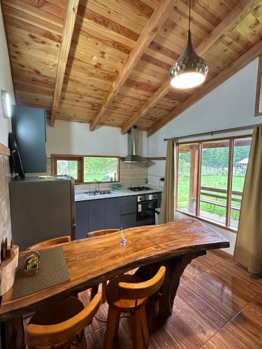a kitchen with a large wooden table and chairs at Casa junto a Ojos del Caburgua in Pucón
