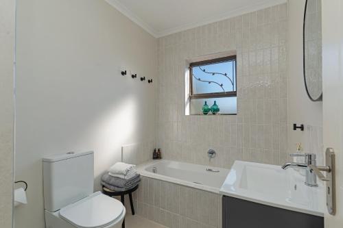 a bathroom with a tub and a toilet and a sink at Cape Goodness in Bellville