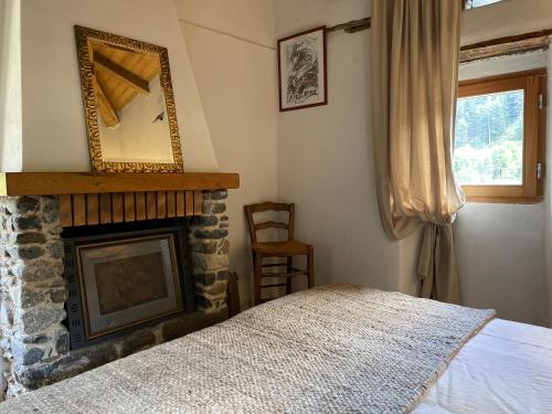 - une chambre avec une cheminée, un miroir et un lit dans l'établissement Le Mazet du Ron des Perles, à Valleraugue