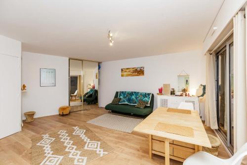 un salon avec un canapé vert et une table dans l'établissement Apartment near Buttes Chaumont, à Paris