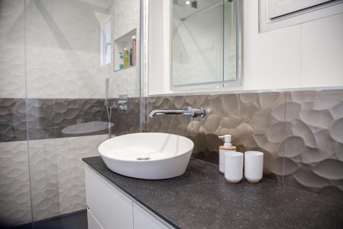 La salle de bains est pourvue d'un lavabo blanc sur un comptoir. dans l'établissement Duplex Vue mer Saint Marguerite, à Pornichet