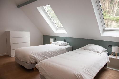 - 2 lits dans une chambre avec 2 fenêtres dans l'établissement Duplex Vue mer Saint Marguerite, à Pornichet