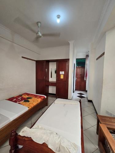 a bedroom with two beds and a kitchen in it at Tulivu Urban - Twiga Hotel in Moshi