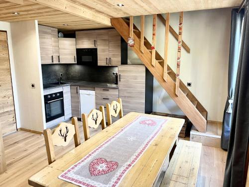 a kitchen with a wooden table and a wooden staircase at Club Alpina - Champagny-en-Vanoise in Champagny-en-Vanoise