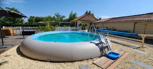 a large inflatable swimming pool in a yard at Lana Cottage 3 Etoiles Jardin in Montjean