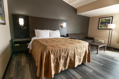 a hotel room with a bed and a couch at Quality Inn & Suites Danbury near University in Danbury