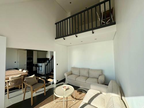 un salon avec un canapé et une table dans l'établissement Duplex Vue mer Saint Marguerite, à Pornichet