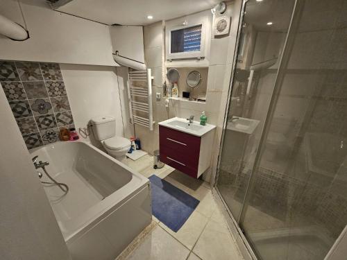 une salle de bain avec une baignoire, des toilettes et une douche dans l'établissement 3 pièces à 50 m de la plage, à Fréjus