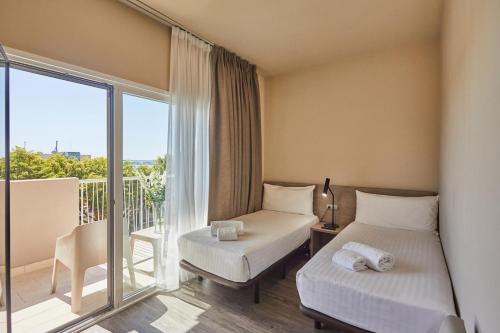 a hotel room with two beds and a balcony at Silken Turcosa 3 Sup in Castellón de la Plana