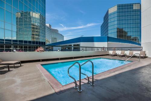 a swimming pool on top of a building with tall buildings at Sonesta Los Angeles Airport LAX in Los Angeles