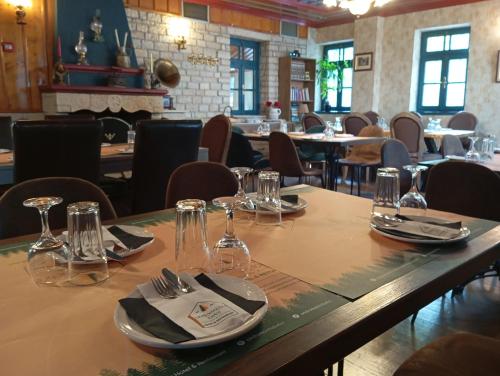 a table in a restaurant with glasses and napkins at Andromachi's beloi hotel in Vitsa