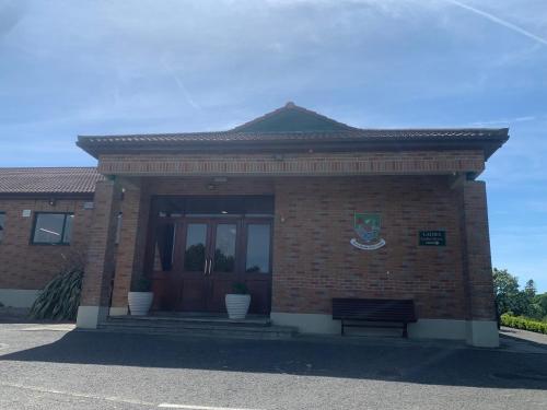 a brick building with a bench in front of it at Relaxing Balcony Views Mullingar Self Catering Apartment on Park Hotel Grounds in Mullingar