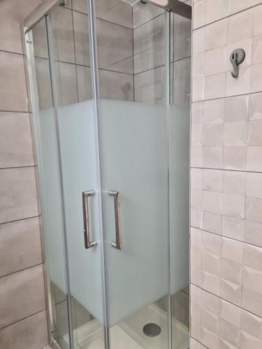 une douche avec une porte vitrée dans une salle de bain dans l'établissement Appartement Saint Cyprien plage réservable du samedi au samedi les mois de Juillet et Aout, à Saint Cyprien Plage