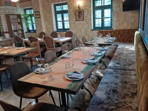 a row of tables in a room with windows at Andromachi's beloi hotel in Vitsa