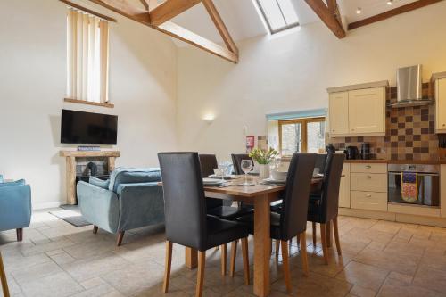 una cucina e una sala da pranzo con tavolo e sedie di Beautiful Barn Conversion with Games Room a Ilfracombe