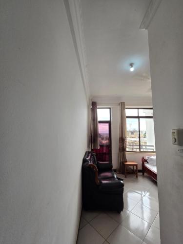 a living room with a black chair and a window at Tulivu Urban - Twiga Hotel in Moshi
